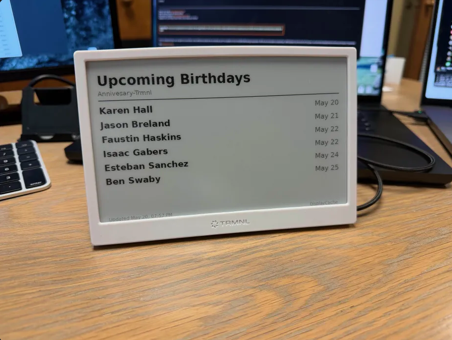 TRMNL e-ink display on a desk showing TouchPoint milestones from DisplayCache